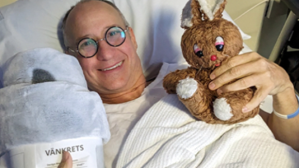 Paul in a hospital bed with stuffed toy