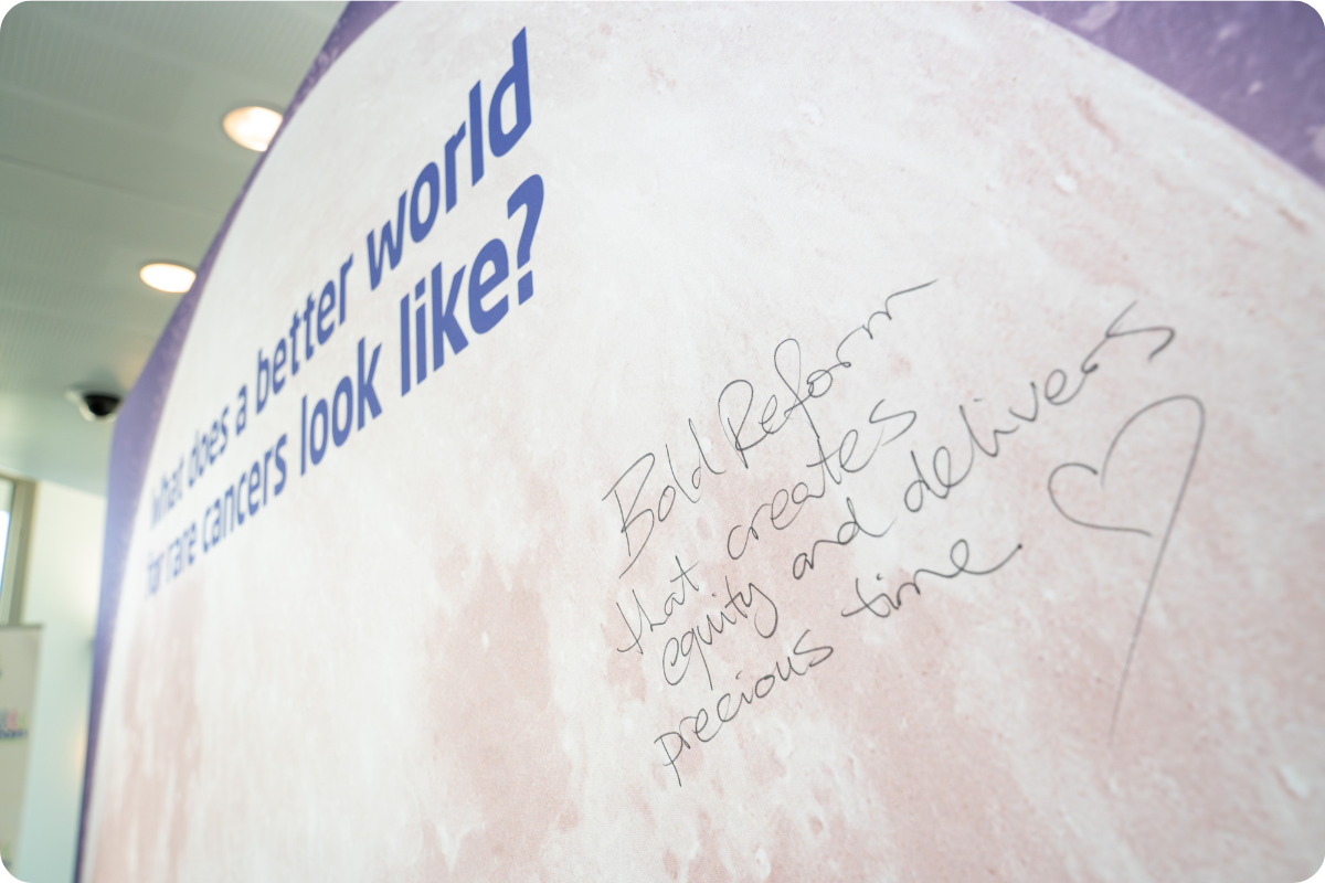 A photo of the RCA 'what does a better world for rare look like' banner with the words "bold reform that creates empathy and delivers precious time".