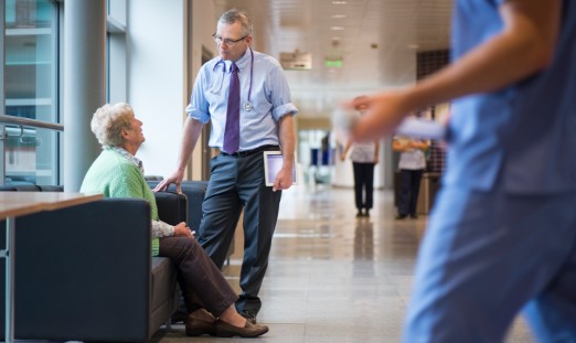A patient seated speaking to a doctor