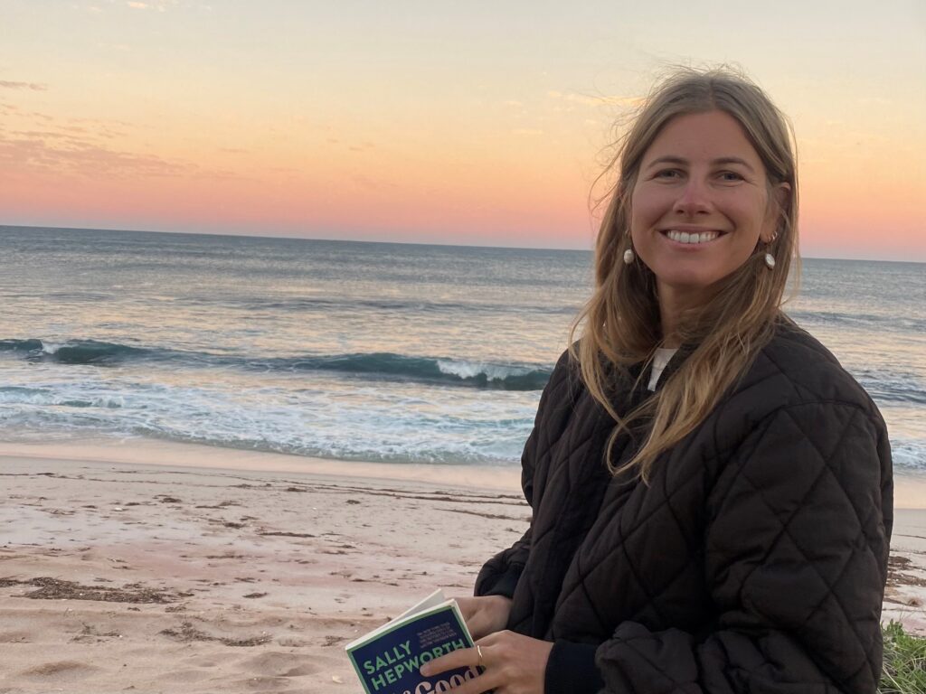Kelly standing on the beach at sunrise.